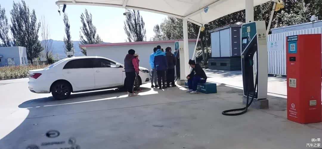 秦和另外一车人在研究充电桩