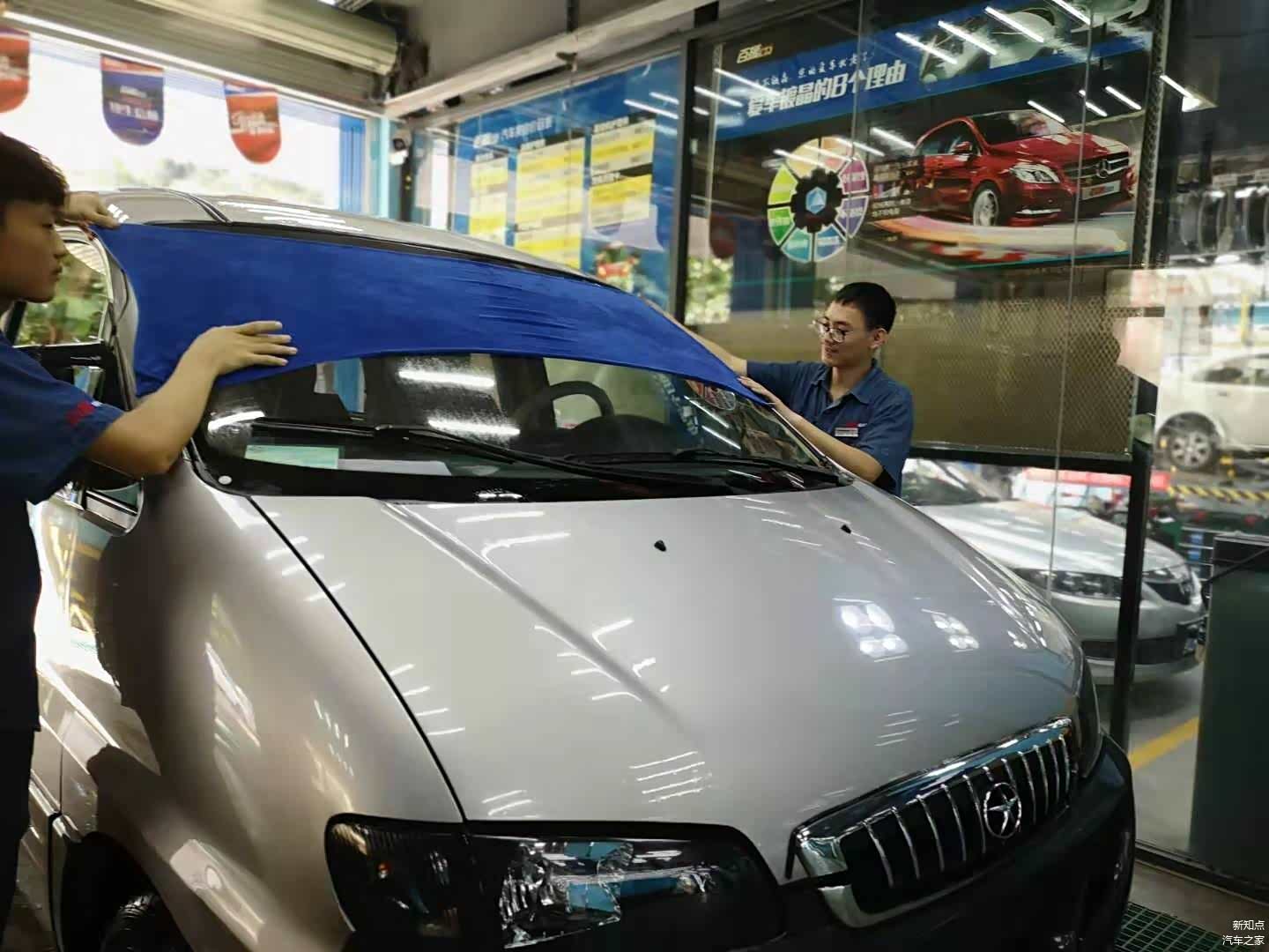 两师傅配合擦拭车表水分