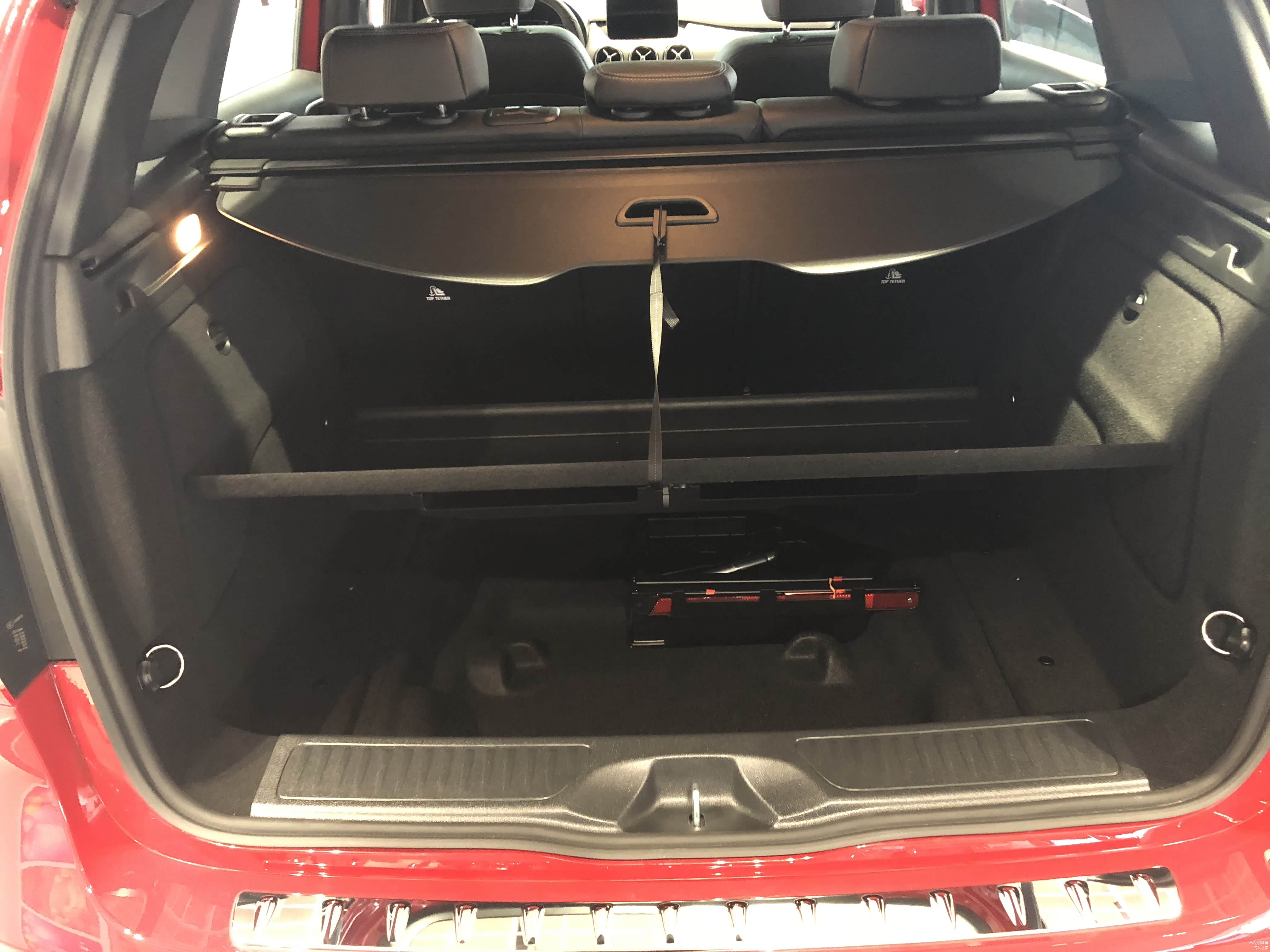 后备箱地板有一个设计上的小心思，当你放东西的时候可以把盖板固定在拉帘上，方便拿去东西